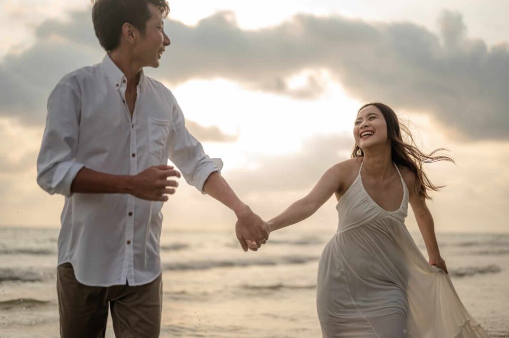 Portrait beach vacation romantic walk couple relaxing on ocean summer travel destination.