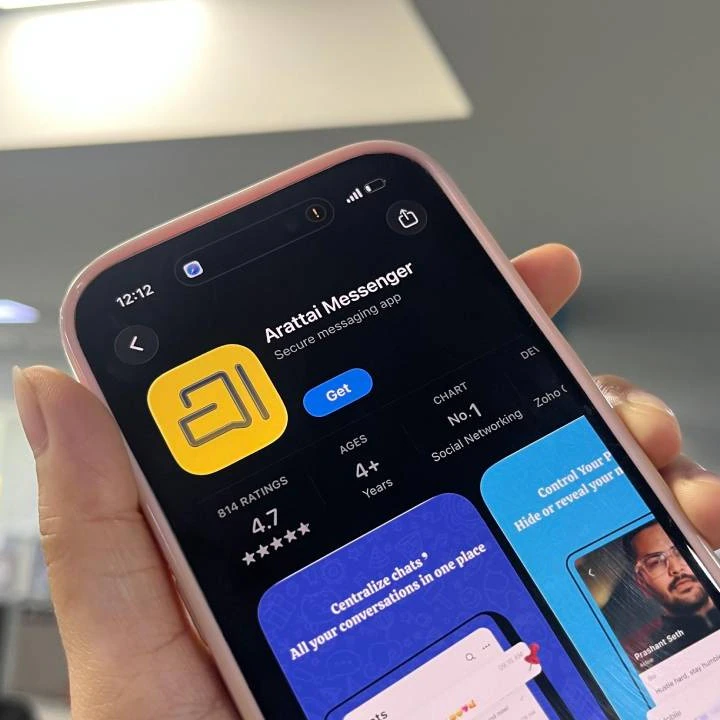 A close-up shot of an iPhone screen displaying the Arattai Messenger app page in the app store, which clearly shows the app's logo, a 4.7-star rating, and the text "CHART No.1 Social Networking."